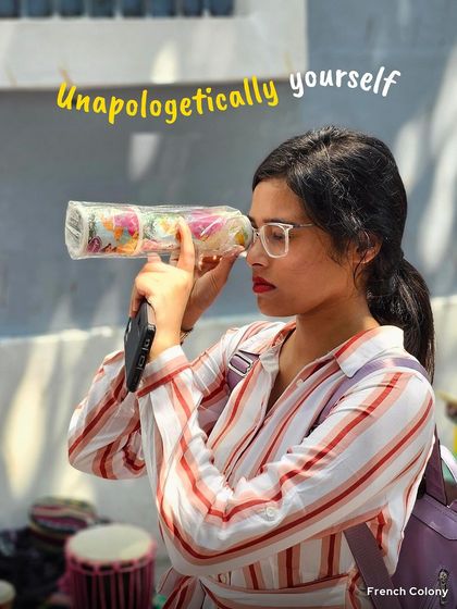 Be unapologetically yourself. A woman playfully looks through a roll of bangles in a French Colony market. My trips are a space to be quirky, fun, and completely you.
