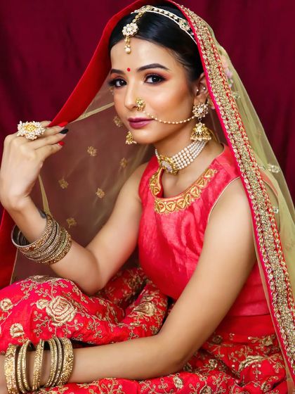 A bride has her own elegance, and my job is to make it shine. This portrait captures the grace of our bride in her beautiful red and gold lehenga-saree.