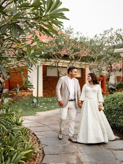 A couple takes a quiet walk through the beautiful Portuguese-style architecture of the Caravela Beach Resort in Goa during their sangeet.