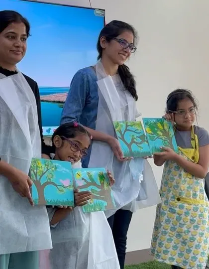 A mother-daughter duo with their matching tree paintings. It's so wonderful to see families create art that connects and complements each other.