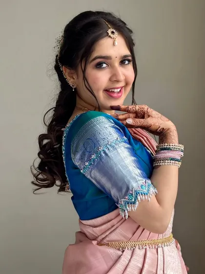The joy on my client's face says it all. For this South Indian traditional look, I used soft pinks on the eyes and lips to complement her silk saree, ensuring her skin looked fresh, dewy, and luminous.