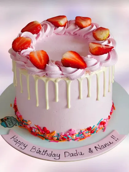 A fresh strawberry drip cake. The combination of pink cream, white chocolate drip, and fresh strawberries is both beautiful and delicious.