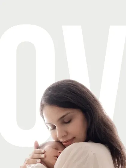 A close-up of a mother holding her newborn baby, her eyes closed in a moment of pure love and contentment. The simple, clean composition focuses entirely on this tender embrace, capturing the essence of new motherhood.