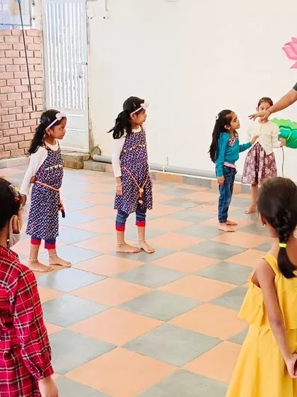 I start a session by explaining the first warm-up activity to an attentive group of children. Clear instructions and a positive attitude are key to getting everyone engaged and ready to move.