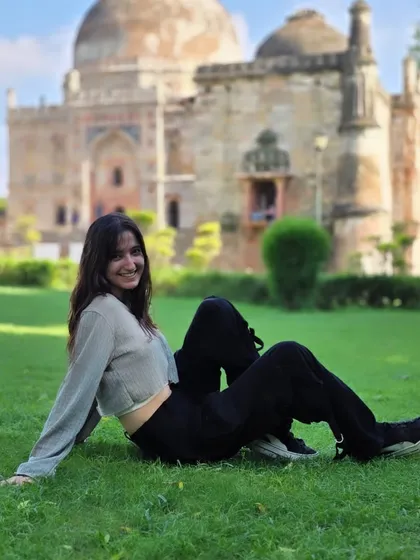 A full-length shot of a relaxed pose on the grass. This composition gives a great sense of the location and the subject's comfortable, happy mood.