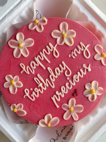 This vibrant pink mini cake is decorated with delicate, hand-piped white flowers and a loving birthday message. It’s a beautiful way to show someone you care.