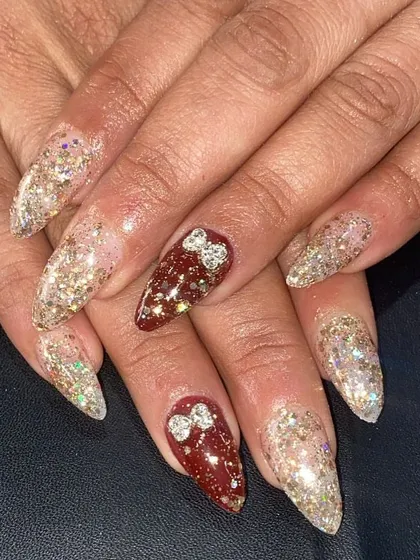 A festive and sparkly set with a mix of red and clear glitter nails, accented with 3D rhinestone bows.