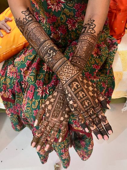 A beautiful example of full coverage bridal mehendi. The design is packed with details, including elephant motifs, intricate jaal patterns, and delicate floral bands.