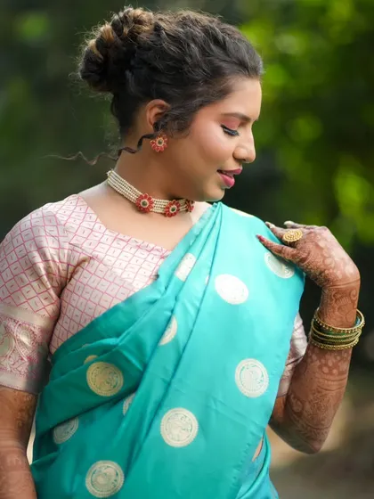 A close-up of the bride's soft makeup and delicate jewelry for her engagement pooja.