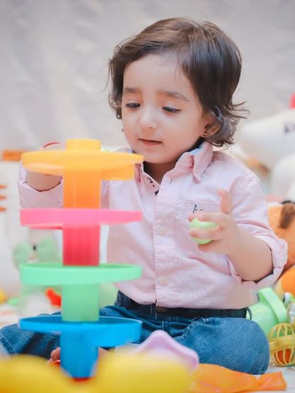Building a tower of rings. We document developmental milestones and the simple joys of play during our toddler sessions.