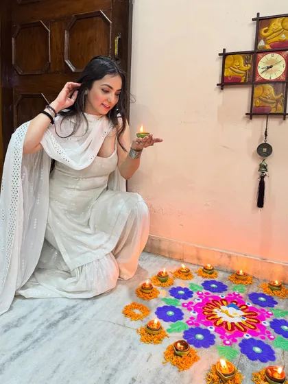 A close-up of my Diwali look, holding a diya. The focus here is on the festive mood and the simple elegance of the white-on-white ethnic outfit.