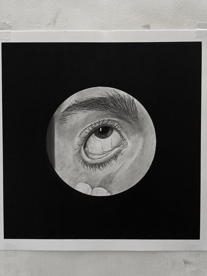 The Day 24 eye drawing, shown on the drawing board. The white border from the tape helps to frame the piece.