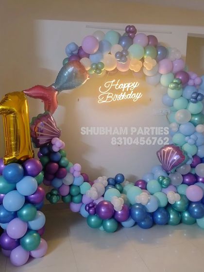A mermaid themed first birthday decoration with a beautiful balloon ring and character foils.