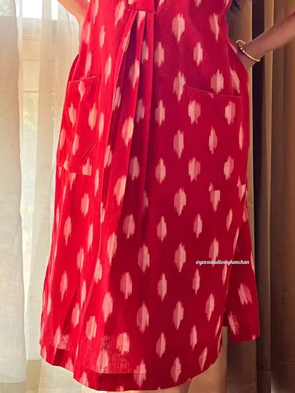 A detailed shot of the red Ikat dress-cum-kurta, highlighting the convenient pockets and the rich texture of the fabric.