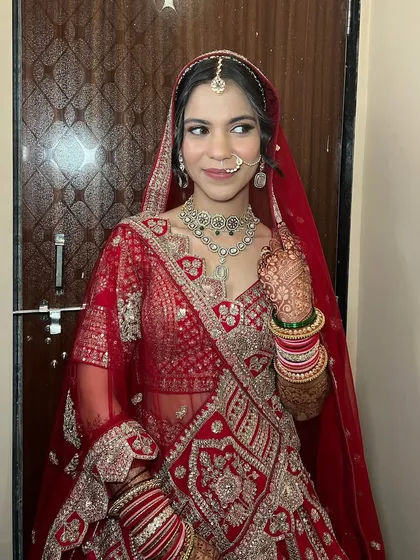 This bride looks absolutely radiant in her red lehenga. The makeup is classic and clean, with a focus on enhancing her features and ensuring the look is timeless.