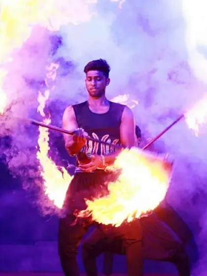 Our fire dancers command the stage with grace and intensity. This performer masterfully manipulates flaming props, painting the air with light and motion against a backdrop of dramatic smoke, creating a truly captivating show.
