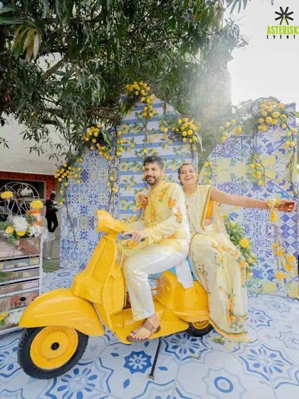 Capturing pure joy and sunshine at a Mediterranean-themed Haldi. This fun photo-op with a vintage yellow scooter was a highlight, perfectly matching the couple's vibrant personalities.