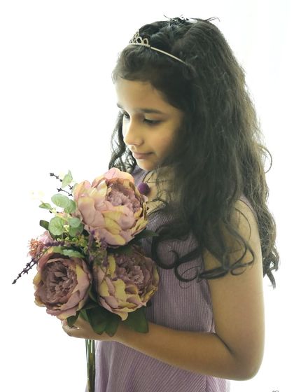 A simple, elegant portrait of a young girl. The soft, high-key lighting creates a gentle and angelic feel, perfect for capturing the innocence of childhood.