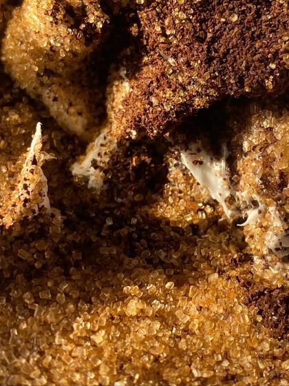 A close-up texture shot of our coffee and sugar scrub, showing the beautiful crystalline structure of the sugar and the rich color of the coffee.