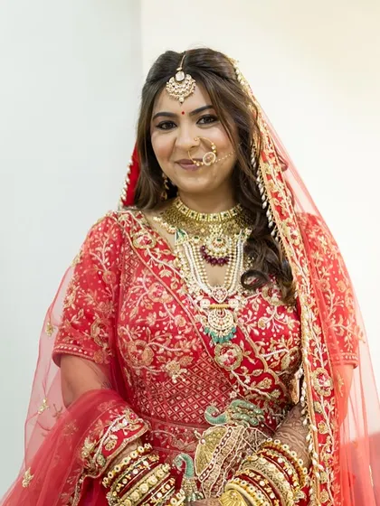 A happy portrait of the bride, showcasing her complete look. The soft waves in her hair and the radiant makeup create a fresh and modern bridal style.