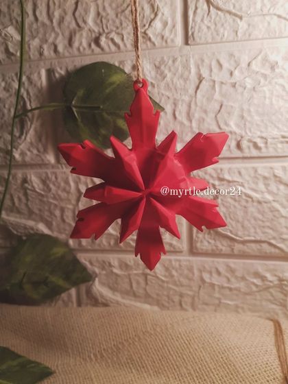 Our red 3D Snowflake Ornament hanging against a simple background. The crisp, clean lines make it a beautiful, minimalist addition to any tree.