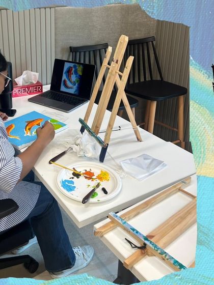 Here's a participant at a corporate workshop, referencing a design on her laptop to create her own koi fish painting. I can tailor the art theme to fit your company's goals or event.