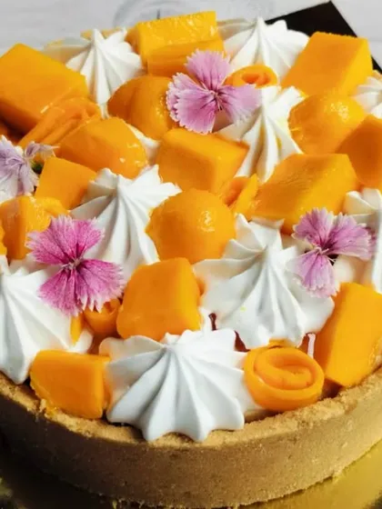 My New York-style eggless baked cheesecake, topped with the sweetness of seasonal mangoes and edible flowers. It's rich, creamy, and utterly decadent.