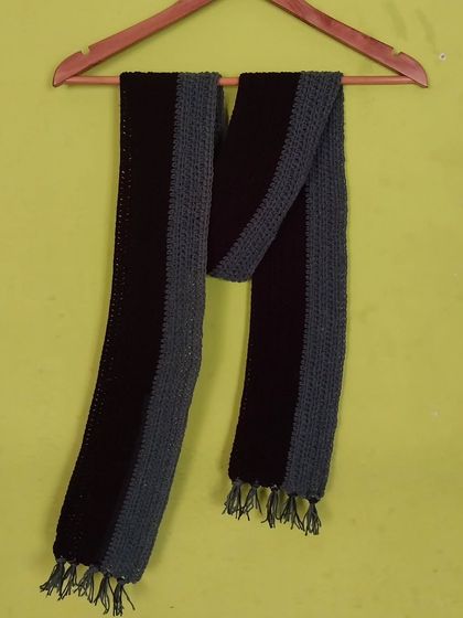 A classic two-toned muffler or scarf, hanging to display its length and design.