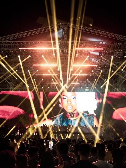 The full stage production for Black Coffee, with golden lasers and a massive LED screen creating a warm, immersive atmosphere.