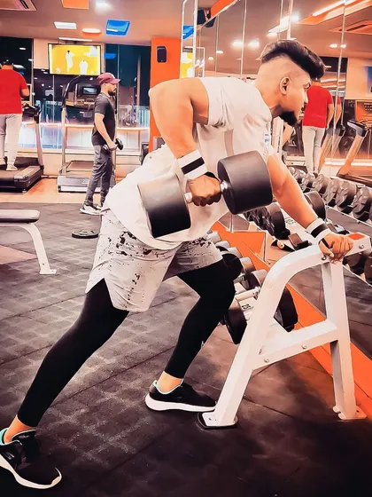 Building a strong back is fundamental to overall fitness. A client performs a single-arm dumbbell row with perfect form, a key exercise in our personal training programs for developing back strength and posture.