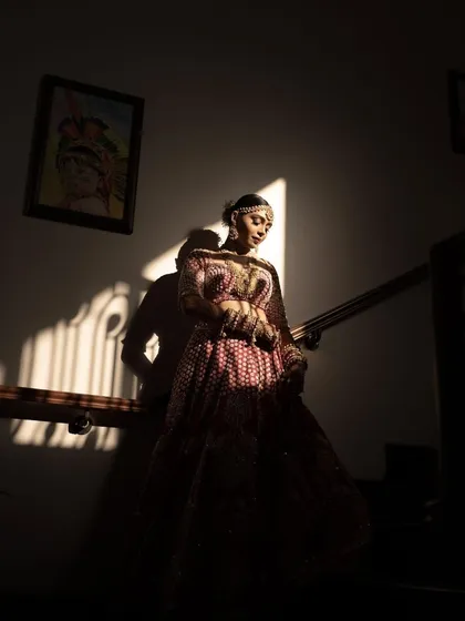 A dramatic bridal portrait using strong shadows and light on a staircase. This artistic shot highlights the bride's silhouette and creates a moody, high-fashion look.