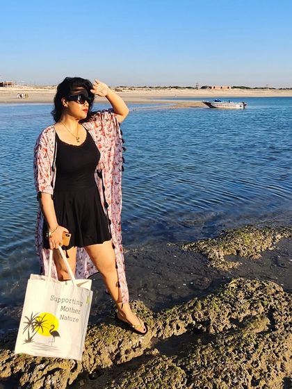 A closer look at the beach outfit, showing the printed shrug and a tote bag that's perfect for carrying essentials.
