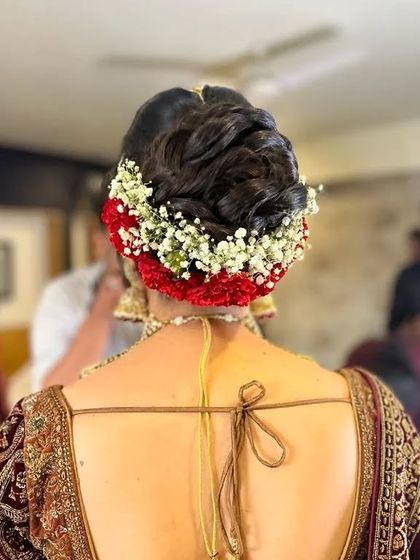 A classic bridal bun surrounded by a gajra of red and white flowers. This is a timeless and elegant choice that never goes out of style.