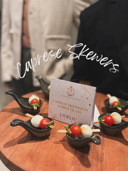 Classic Caprese Skewers, featuring cherry tomatoes, fresh mozzarella, and basil, served in individual shot glasses. A simple, fresh, and elegant choice for any occasion.