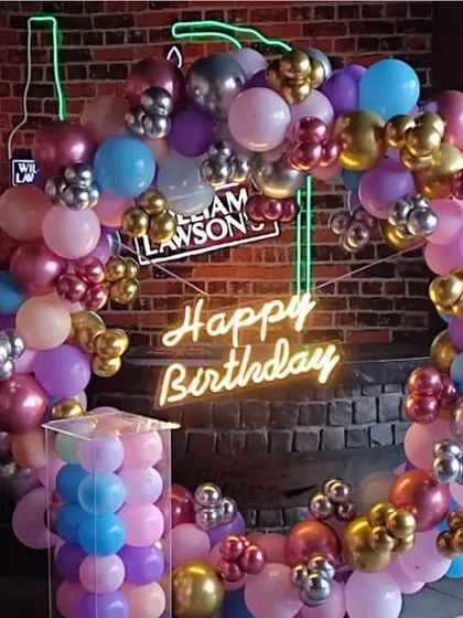 A vibrant, multi-colored balloon ring against a brick wall. This setup uses a mix of metallic and pastel balloons for a fun and eclectic look, perfect for a bar or restaurant party.