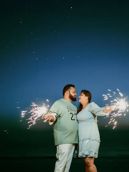 A fun and joyful night shot of a couple with sparklers under a starry sky. This creative pre-wedding photo is full of energy and wonder, perfect for an adventurous couple.