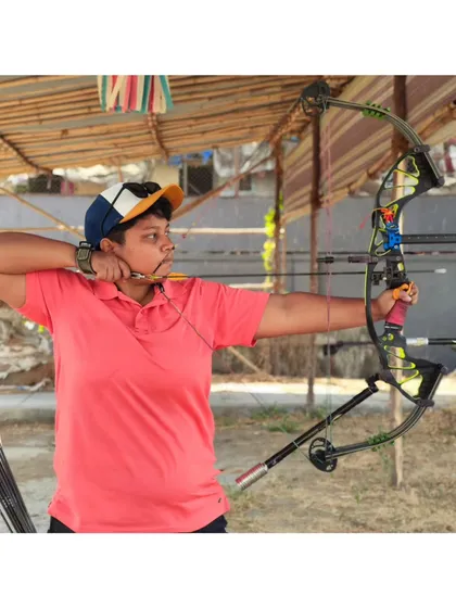 A student takes aim with a compound bow. We offer specialized coaching for both recurve and compound archery, catering to each archer's competitive goals.