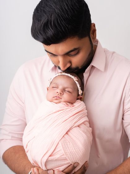 A father's love. This portrait of a dad kissing his newborn's head is a classic and heartwarming image.