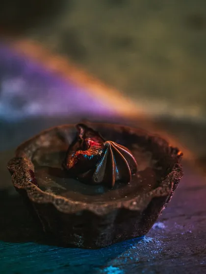 An experimental shot of a chocolate tart with a rainbow light flare. This shows how to play with creative lighting effects to create a unique image.
