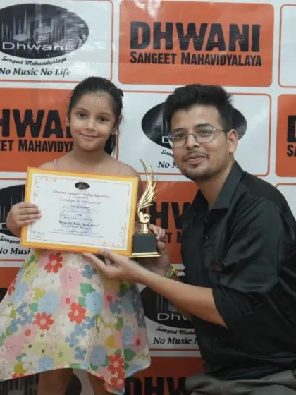 A teacher presents an award to a young student.