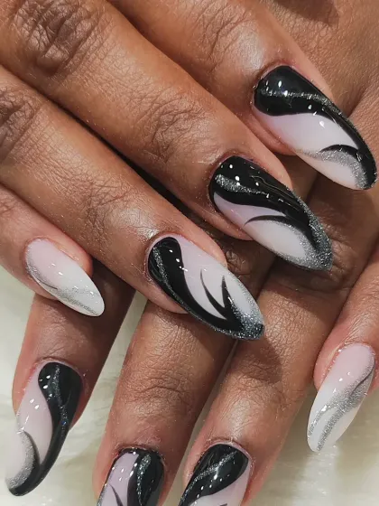 Abstract art for your fingertips. This long, stiletto set features a mesmerizing black and silver glitter swirl design on a sheer base, creating a dynamic and artistic statement.