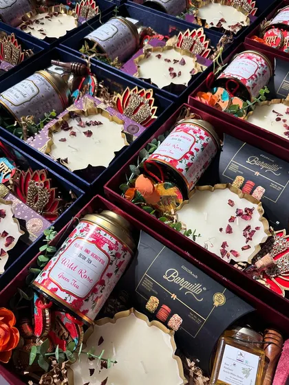 A beautiful flat-lay of our Diwali hampers, showcasing the rich textures and colors. The combination of wild rose tea, gourmet wafers, and decorative candles creates a luxurious feel.