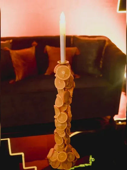 A unique centerpiece detail. For this futuristic sangeet, we created a candelabra decorated with dried orange slices, blending natural elements with a quirky, modern aesthetic.