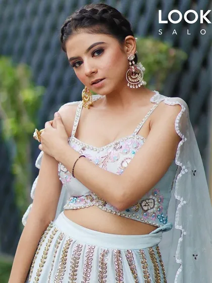 A confident pose from the model, showing off her festive makeup and hairstyle. The look is fresh, modern, and elegant.