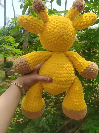 Holding up the big giraffe plushie to show her full size and cuddly body. This was a joy to make, and I can create a similar large friend for you in your favorite colors.