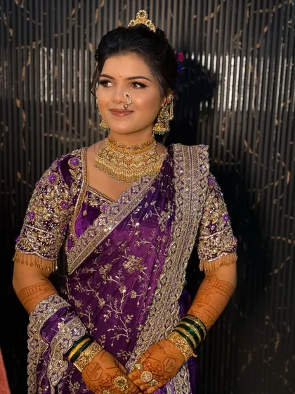 A portrait of the bride in her purple Nauvari, showcasing her confident smile and traditional jewellery.