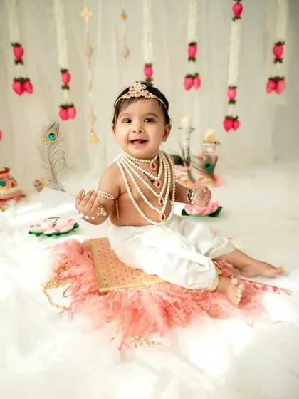 A joyful baby dressed as Krishna for Janmashtami. The bright smile and festive setup make this a perfect portrait to celebrate the occasion.