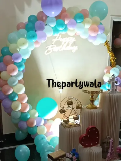 A dreamy pastel rainbow balloon ring with a neon "Happy Birthday" sign. The soft colors are perfect for creating a gentle and magical atmosphere.