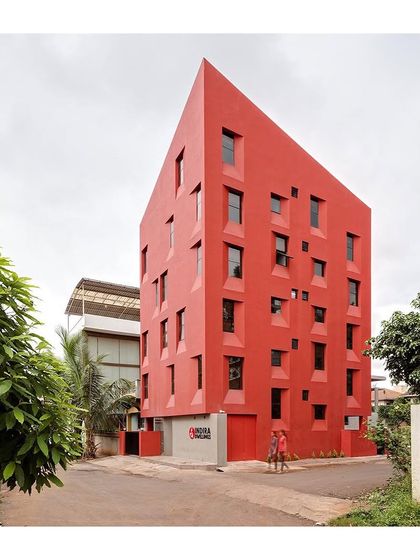 This image captures the striking presence of the "Stacked Student Housing" project. The uniform red color unifies the complex form, making it read as a single, powerful object in the landscape.