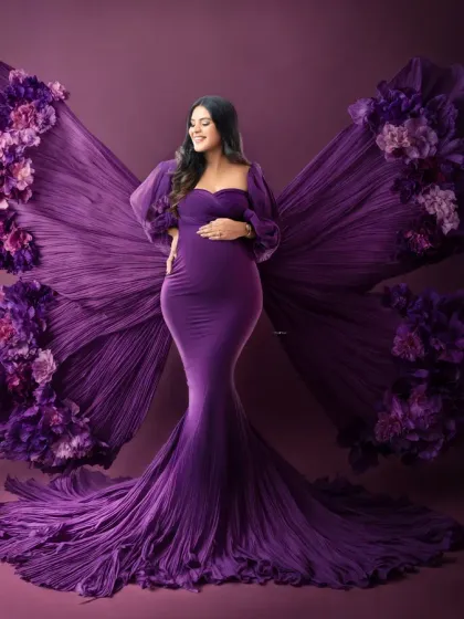 Transforming into a mother. This creative portrait uses a stunning purple gown with large, butterfly-like wings made of pleated fabric. It's a beautiful metaphor for the transformation of pregnancy, captured in a high-fashion, artistic style.